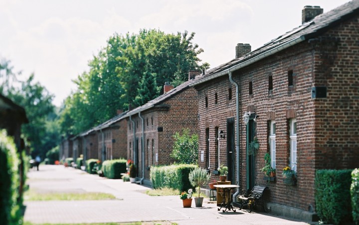 Häuserzeile der Siedlung Eisenheim aus niedrigen Backsteinhäusern und kleinen Vorgärten.