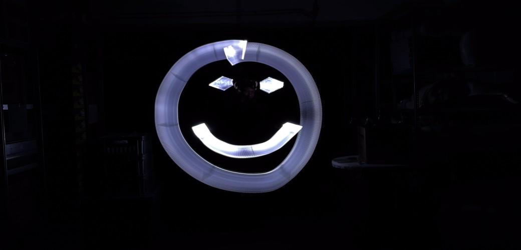 Ein lächelnder Emoji auf dunklem Hintergrund. 