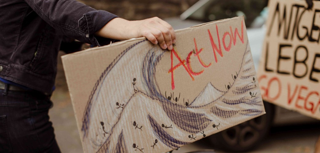 Plakat mit der Aufschrift "Act Now"