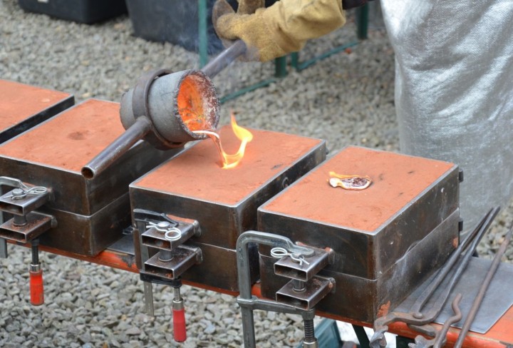 Heißes Metall wird in Formen gegossen. 