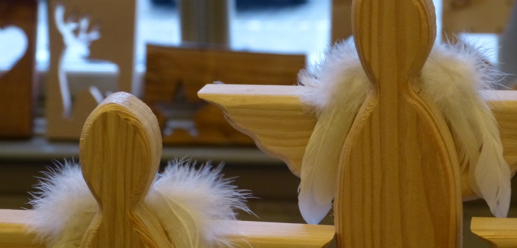 Zwei Engelsfiguren aus hellem Holz mit weißen Flügeln aus Federn