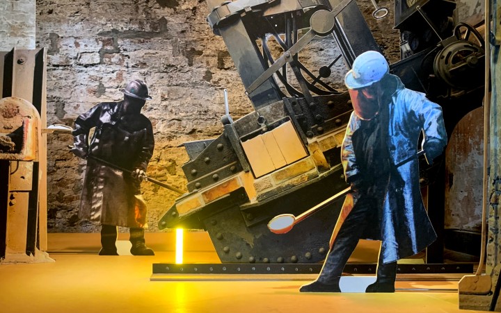 Szenenbild des Papiertheaters „Knösterpitter” mit zwei Arbeitern in Arbeitskleidung bei der Produktion.