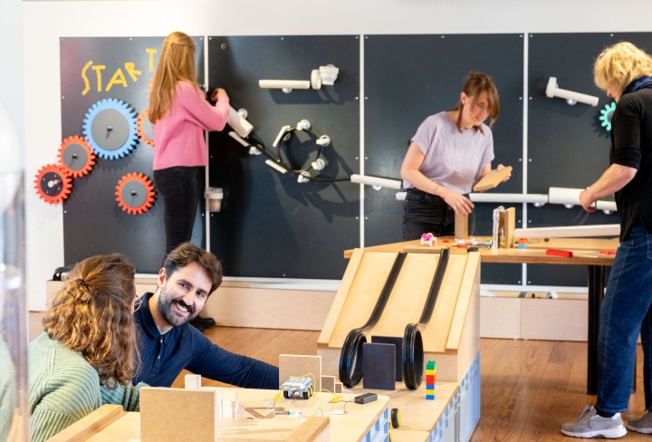 Erwachsene tüfteln an Magnetwand