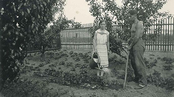 Ein Schwarzweißfoto aus den 30er Jahren zeigt eine junge Frau und einen jungen mann bei der Gartenarbeit.